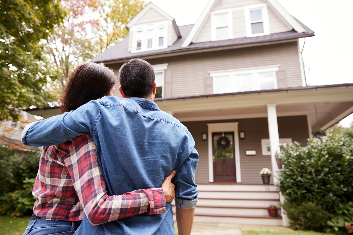 Young couple looking at their home. 